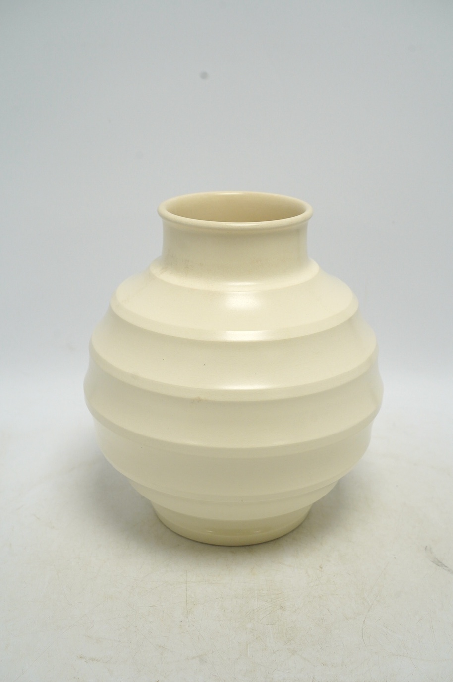 Keith Murray for Wedgwood, a cream glazed ribbed globular vase, 23cm. Condition - fair, star crack visible to base from interior